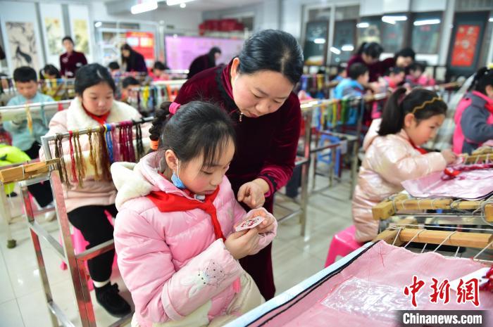 江西省級非遺豫章繡傳承人手把手指導小學生繡制2022年北京冬奧會吉祥物“冰墩墩”形象?！∮髟屏?攝