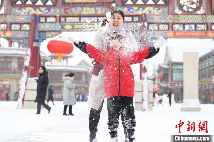 2月13日，家長與小朋友在呼和浩特市大召廣場享雪趣?！⑽娜A 攝