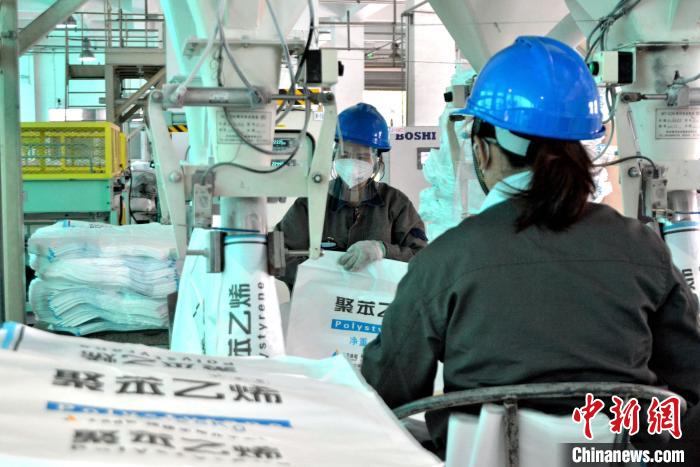 工人在生產(chǎn)線上包裝聚苯乙烯產(chǎn)品?！×趾霔v 攝