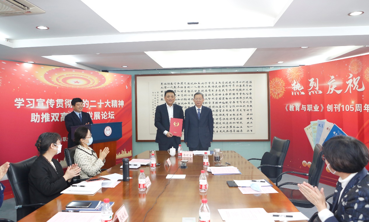 郝明金為《教育與職業(yè)》雜志編委代表陳曉明頒發(fā)聘書。中華職教社供圖
