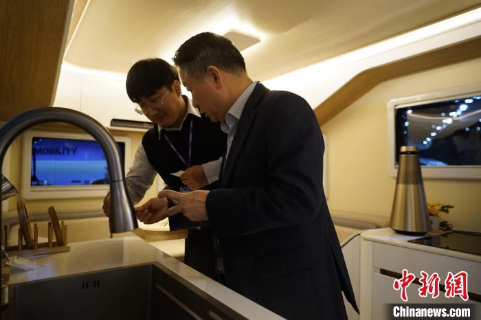 圖為參展商向觀眾介紹房車內部設計?！⑿?攝