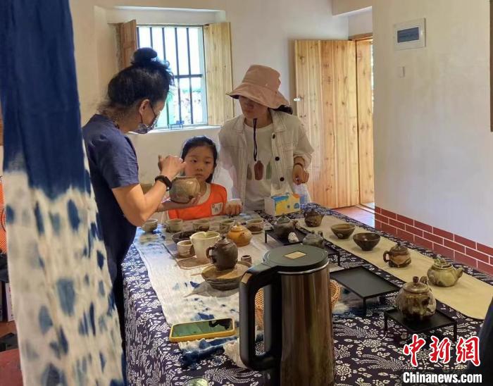 圖為：游客正在咨詢臺(tái)灣柴燒作品?！∪~秋云 攝