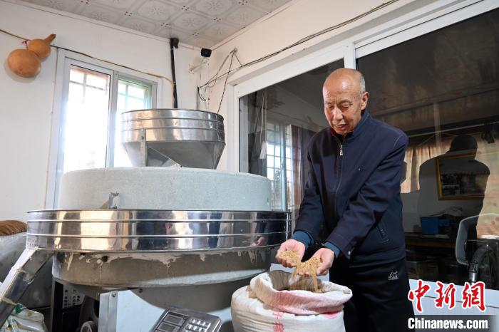 李家莊村民谷文朝重拾父輩的手藝，做起石磨面粉的營(yíng)生?！〉杂鸺?攝