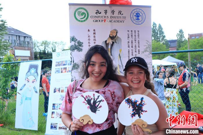 孩子們展示自己的吹墨畫團(tuán)扇作品?！◆斻肟鬃訉W(xué)院供圖