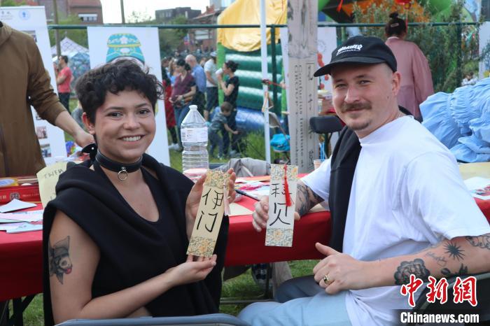 當(dāng)?shù)孛癖娫跐h字體驗工作坊展示自己手寫的中文名書簽。　魯汶孔子學(xué)院供圖