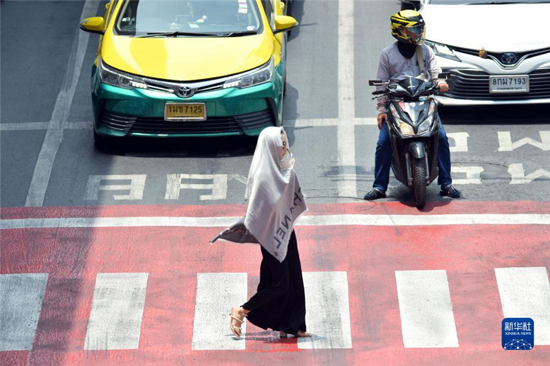 5月17日，行人在泰國曼谷街頭用圍巾遮陽。新華社發(fā)（拉亨攝）