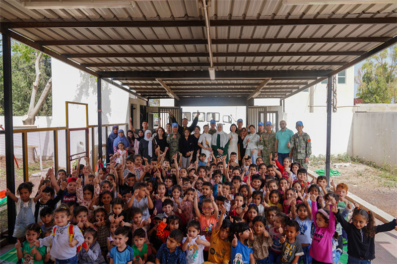 當?shù)貢r間5月30日，黎巴嫩南部庫雷拉公立小學(xué)，“六一”國際兒童節(jié)前夕，中國第21批赴黎維和多功能工兵分隊官兵看望慰問學(xué)校師生，并開展文化交流活動，圖為我維和官兵同師生合影。李竹林攝