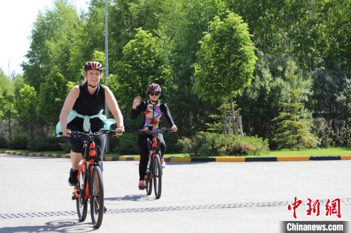 亞信副秘書(shū)長(zhǎng)遲方(右一)與聯(lián)合國(guó)駐哈協(xié)調(diào)員在騎行活動(dòng)中?！喰琶貢?shū)處供圖