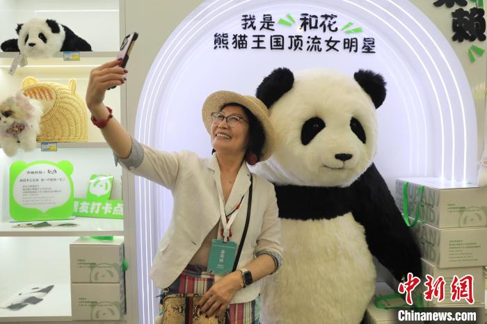 美國華視總裁楊蓮花與大熊貓文創(chuàng)產品合影?！⊥趵?攝