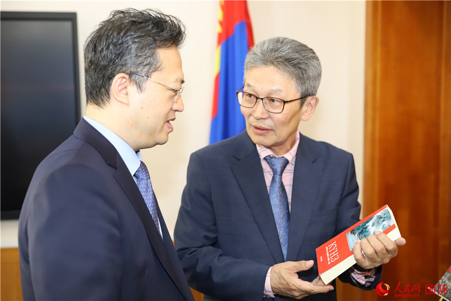 其米德策耶（右一）向李峙介紹翻譯成果。人民網(wǎng)記者 霍文攝