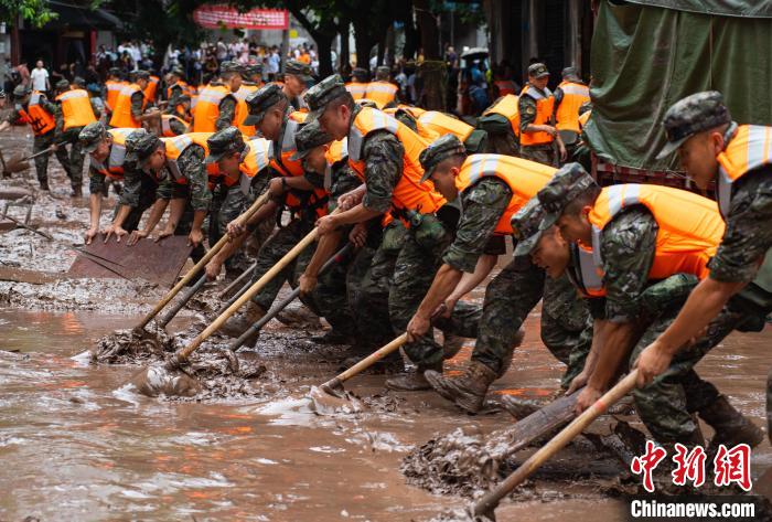 7月4日，萬州區(qū)五橋街道，武警官兵清理街道上的淤泥。　冉孟軍 攝