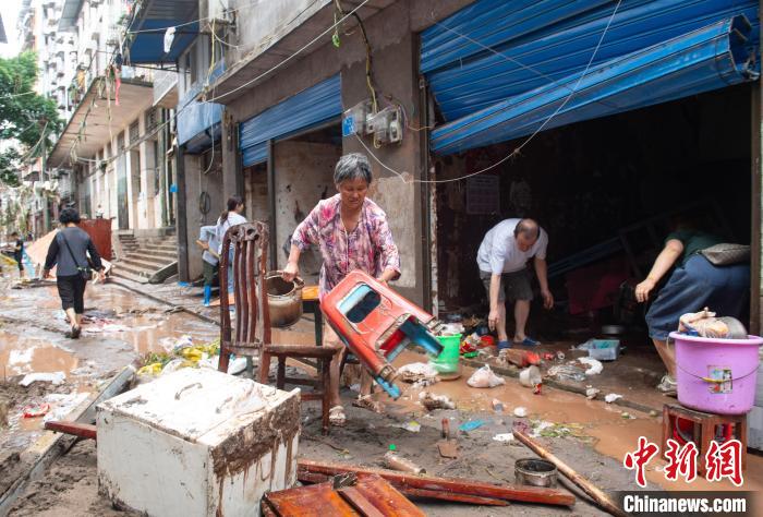 7月4日，萬州區(qū)五橋街道，洪水退去后，居民搶救生活物資?！∪矫宪?攝