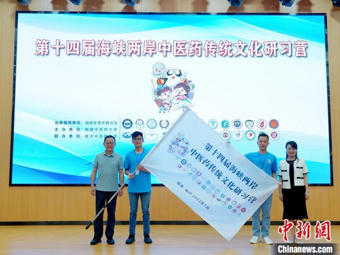 共青團(tuán)福建省委副書記吳雪(右一)、福建中醫(yī)藥大學(xué)黨委副書記林羽(左一)為兩岸學(xué)生代表頒授營旗?！≡S燁婷 攝