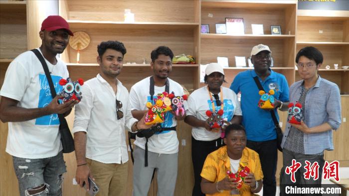 圖為國際青年代表展示親手制作的東營非遺黃河口布偶 。　齊魯 攝