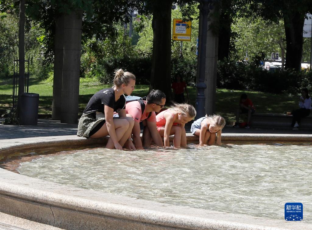 7月8日，人們在德國法蘭克福的一處噴泉玩水。近日，德國法蘭克福逐漸迎來暑熱天氣。新華社記者 張帆 攝