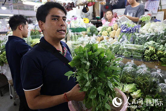 7月19日，泰國曼谷藍(lán)象餐廳員工向參加活動(dòng)的多國代表介紹如何挑選新鮮蔬菜。 人民網(wǎng)記者 張矜若攝