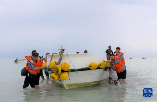 7月21日，中國海軍“和平方舟”號醫(yī)院船醫(yī)護人員涉水登島，前往基里巴斯一診療點。新華社記者 黎云 攝