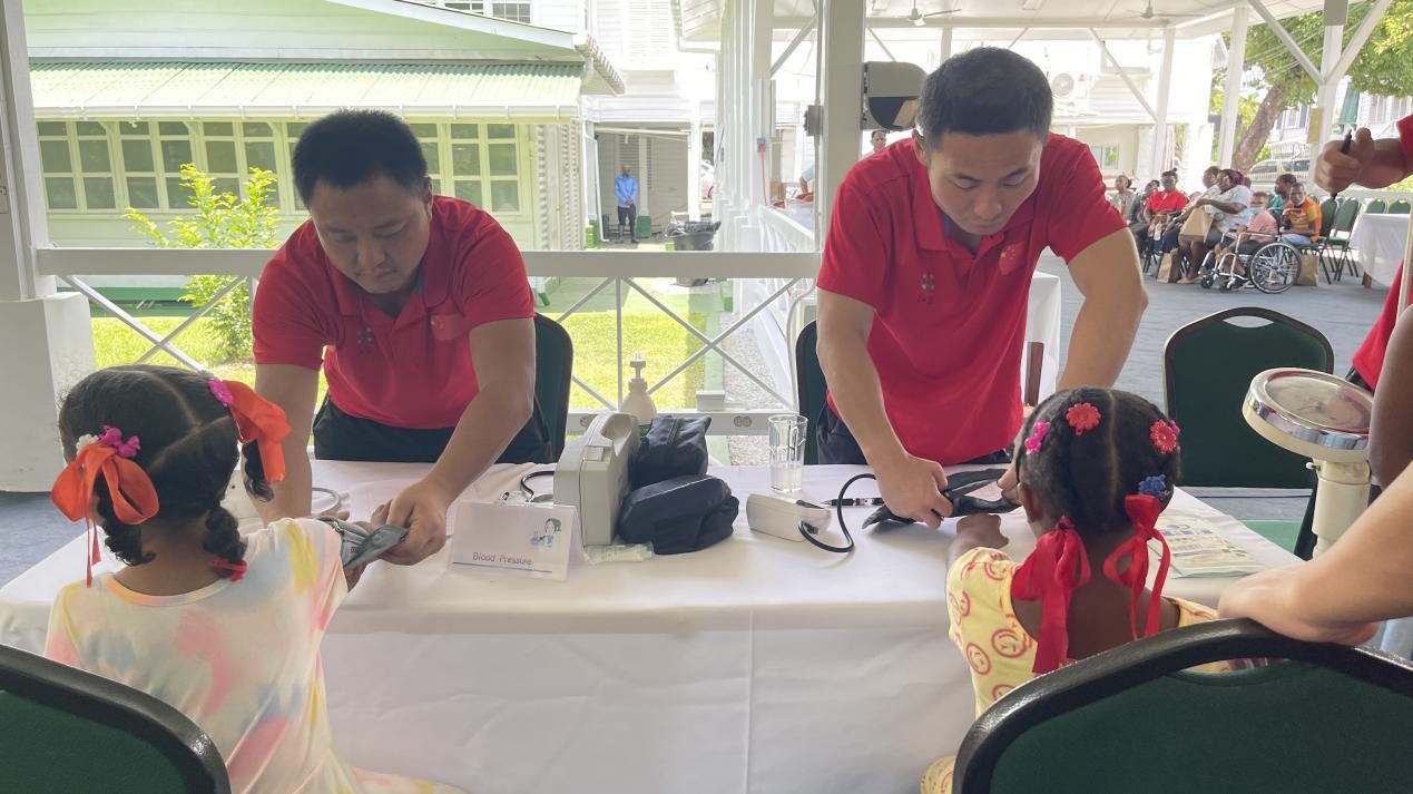 醫(yī)療隊(duì)員為福利院兒童進(jìn)行檢查。第18期援圭亞那醫(yī)療隊(duì)供圖