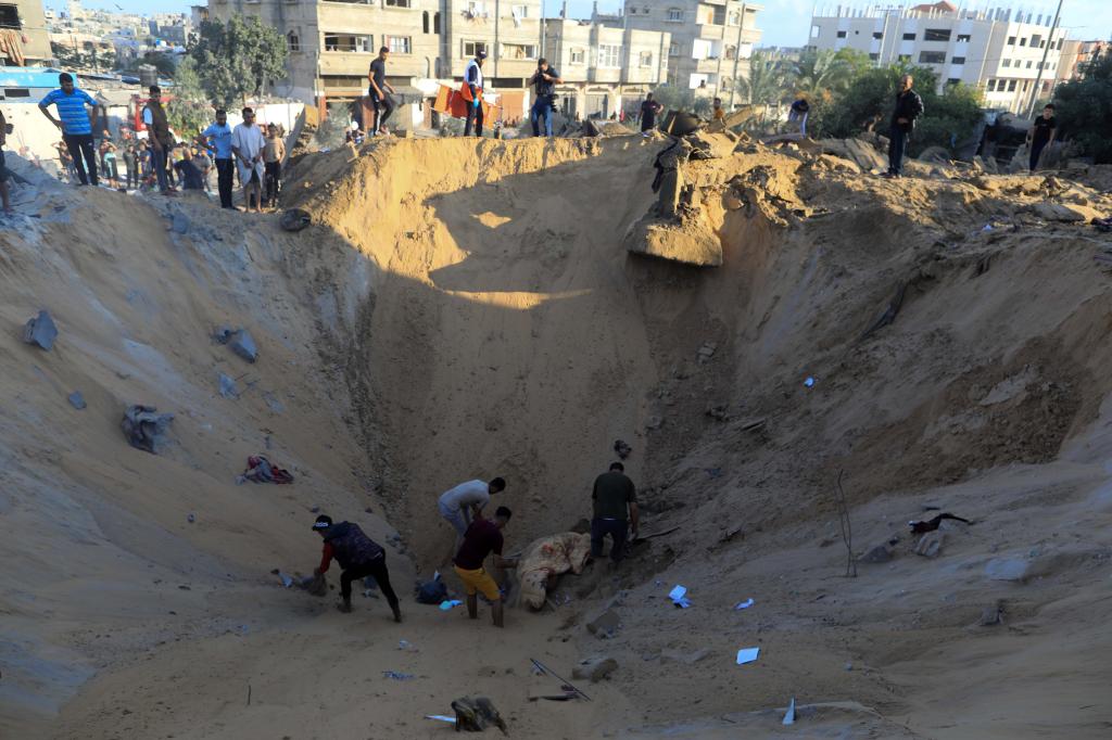 10月16日，在加沙地帶南部城市汗尤尼斯，人們?cè)谠庖陨幸u擊后的建筑廢墟中救援傷者。 新華社發(fā)（亞西爾·庫(kù)迪 攝）