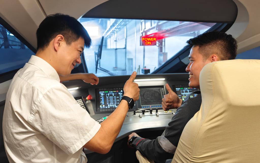 8月25日，在印度尼西亞萬(wàn)隆的雅萬(wàn)高鐵德卡魯爾動(dòng)車(chē)所內(nèi)，中國(guó)師傅穆振（左）在向印尼火車(chē)司機(jī)塞蒂亞萬(wàn)講解動(dòng)車(chē)組出庫(kù)前的上電作業(yè)。