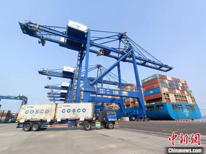 圖為海南洋浦國際集裝箱碼頭，卡車將集裝箱從后方堆場運(yùn)往碼頭裝卸區(qū)?！?jiān)潞?攝