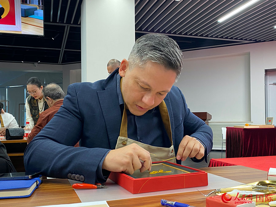 2023“一帶一路”媒體合作論壇聯(lián)合采訪團(tuán)團(tuán)員，親身體驗(yàn)景泰藍(lán)工藝。人民網(wǎng)記者 于洋攝