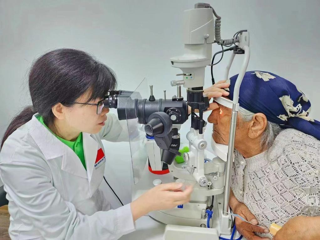 北京大學(xué)人民醫(yī)院眼科醫(yī)生鮑永珍正在為中亞白內(nèi)障患者進(jìn)行眼部檢查。（北京大學(xué)人民醫(yī)院供圖）
