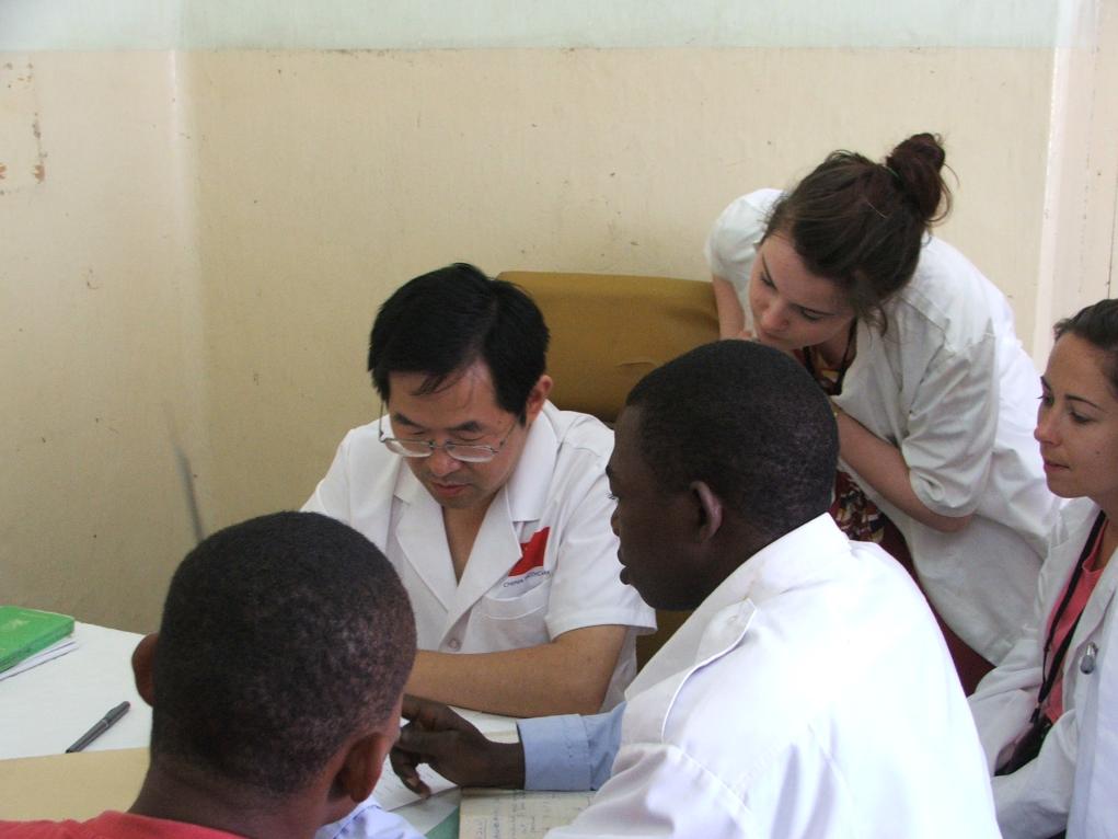 2011年7月22日，在坦桑尼亞桑給巴爾納茲莫加醫(yī)院外科門診，中國(guó)第24批援桑給巴爾醫(yī)療隊(duì)隊(duì)長(zhǎng)盧建林為當(dāng)?shù)鼗颊咴\治并帶教實(shí)習(xí)生。新華社發(fā)（國(guó)家衛(wèi)生健康委供圖）