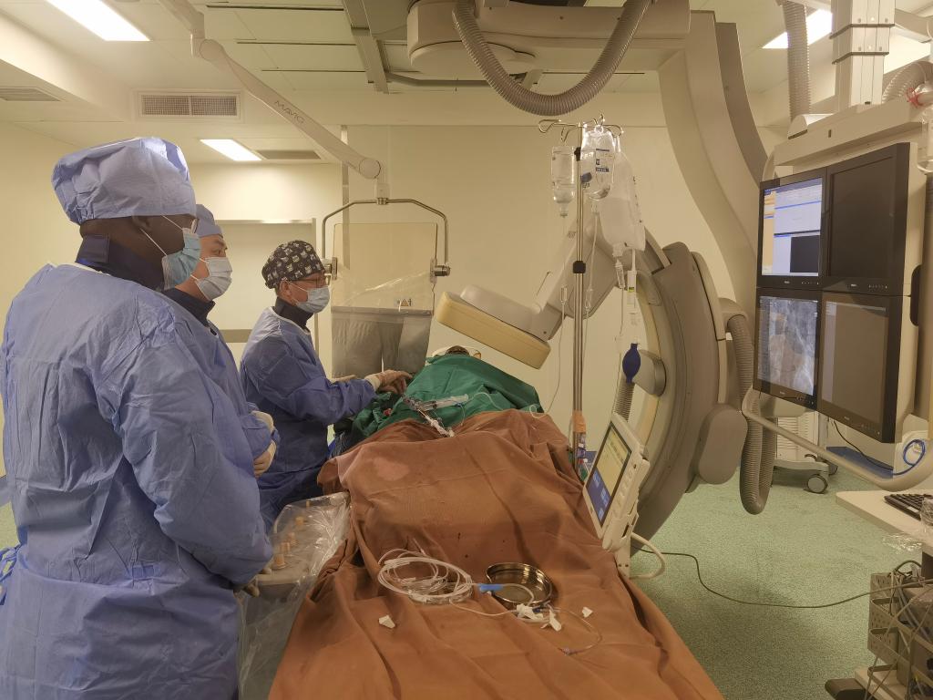 中國(guó)第29批援幾內(nèi)亞醫(yī)療隊(duì)隊(duì)員、首都醫(yī)科大學(xué)附屬北京天壇醫(yī)院心內(nèi)科副主任醫(yī)師王汝朋（右一）正在給患者做手術(shù)。（北京天壇醫(yī)院供圖）