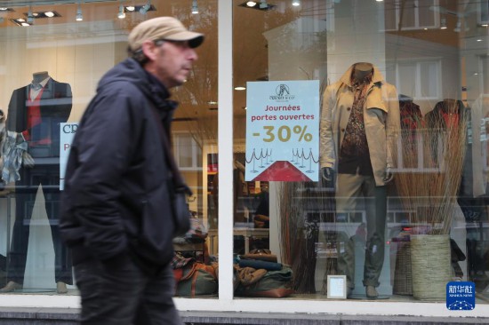   10月31日，一名男子從比利時布魯塞爾一家貼有打折信息的店鋪前走過。新華社記者 趙丁喆 攝
