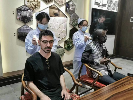 2023“一帶一路”媒體合作論壇聯(lián)合采訪團(tuán)團(tuán)員在九牛草展示館體驗(yàn)艾灸。（本報(bào)記者 黃超攝）