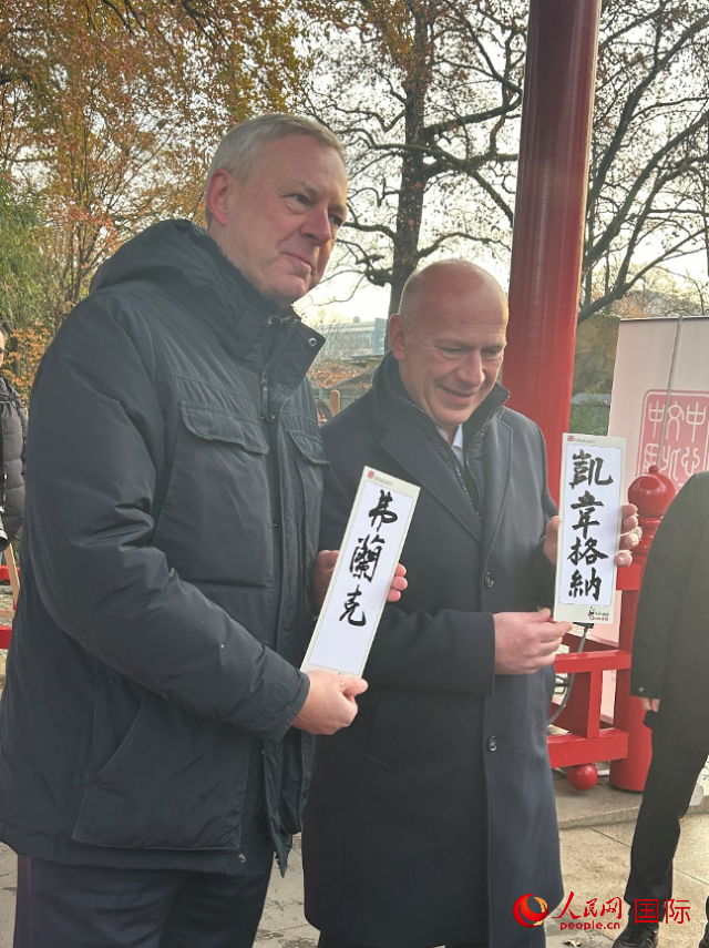 柏林市長韋格納（右）、動物園監(jiān)事會主席布魯克曼（左）手持中國文化中心工作人員現(xiàn)場手書的中文名字。人民網(wǎng)記者 徐馨攝