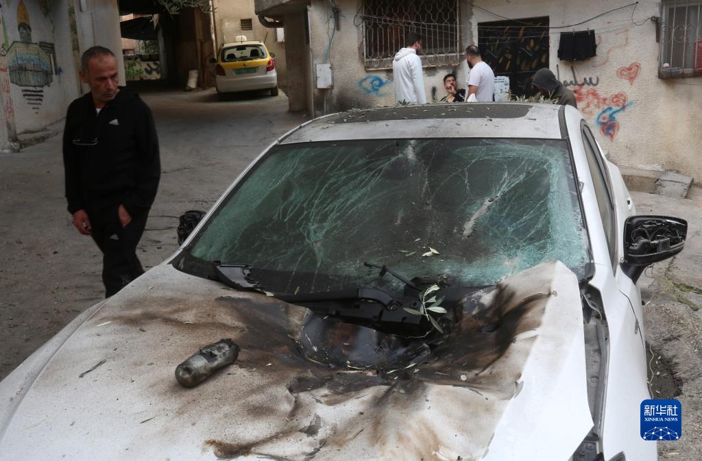 12月17日，在約旦河西岸城市圖勒凱爾姆附近的一處難民營(yíng)，人們查看在沖突中損毀的車輛。新華社發(fā)（尼達(dá)爾·艾仕塔耶?dāng)z）