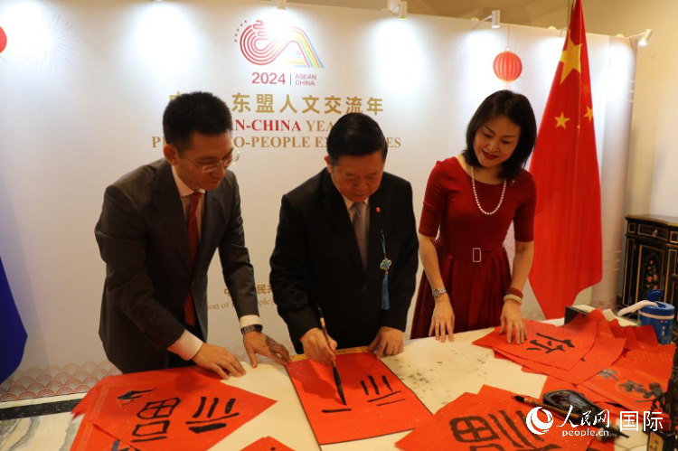 東盟秘書長(zhǎng)高金洪（中）在活動(dòng)現(xiàn)場(chǎng)寫福字。人民網(wǎng)記者曹師韻攝