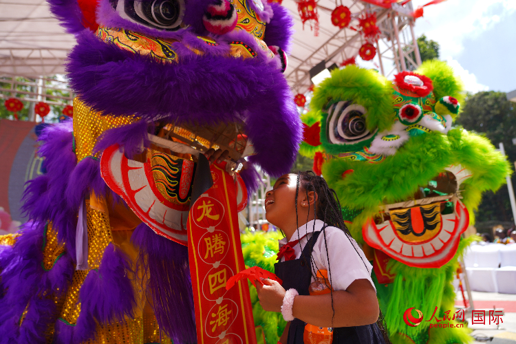 小朋友與舞獅表演者互動。人民網(wǎng)記者 黃煒鑫攝