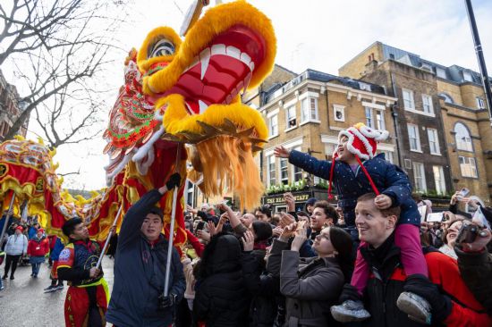 2月11日，人們在英國倫敦的新春巡游活動中觀看舞龍表演。新華社發(fā)（史蒂芬·程攝）