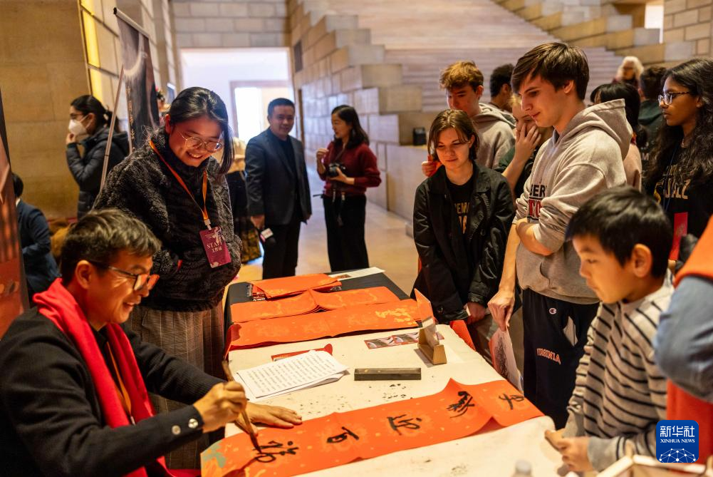 2月11日，書法家在美國費(fèi)城藝術(shù)博物館舉行的龍年迎新春活動上為參觀者書寫對聯(lián)。新華社發(fā)（周煥新攝）