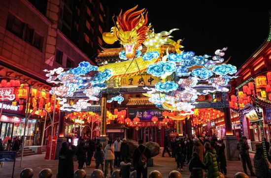 2月11日，游客在沈陽中街游覽。春節(jié)期間，各地?zé)艋痂病⒒饦溷y花，呈現(xiàn)出一幕幕流光溢彩的視覺盛宴。（新華社記者潘昱龍攝）