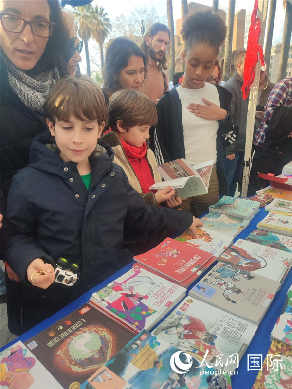 印刷精美的中國傳統(tǒng)文化叢書吸引了小游客的注意。人民網(wǎng)記者鄭彬攝