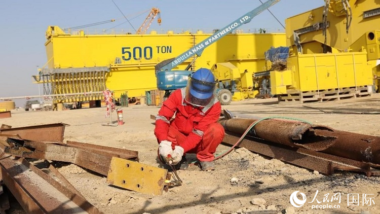 工人正在龍門(mén)吊吊裝現(xiàn)場(chǎng)切割金屬件。人民網(wǎng)記者管克江攝