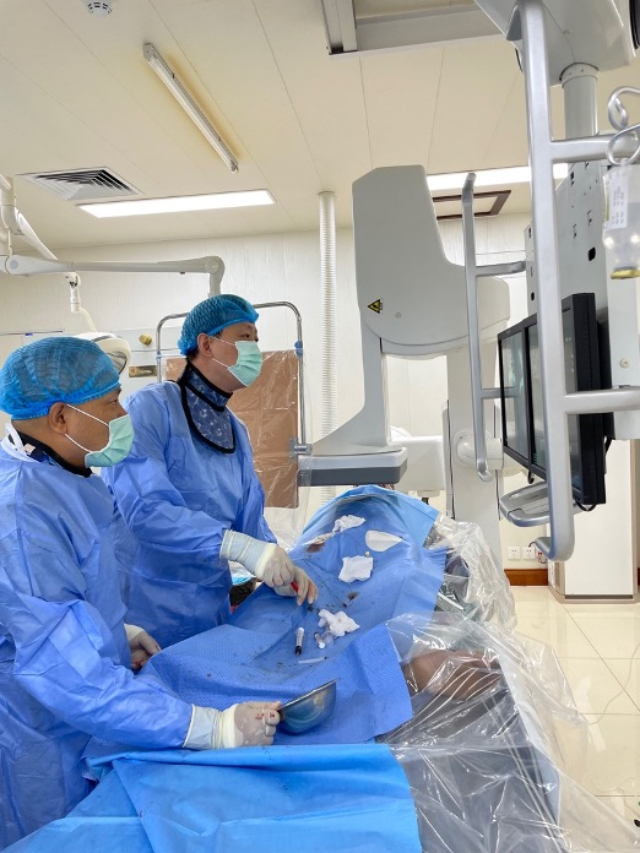 李凱教授（右）和劉海濤教授（左）為患者行TACE手術。中國駐老撾大使館供圖