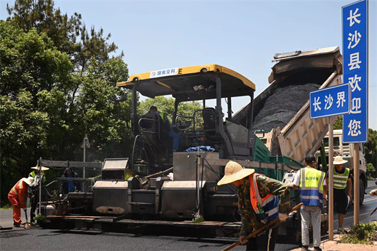 工人正在進(jìn)行“極薄磨耗層”路面的鋪筑。受訪單位供圖