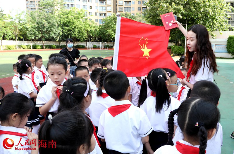老師向少先隊(duì)員展示隊(duì)旗。人民網(wǎng) 符武平攝