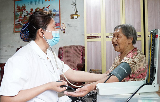 護(hù)理團(tuán)隊(duì)醫(yī)生為老人測量血壓。 陳佳兵攝