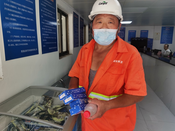 1環(huán)衛(wèi)工倪建宏小憩后，為還同事帶去冷飲。人民網(wǎng)記者王繼亮攝