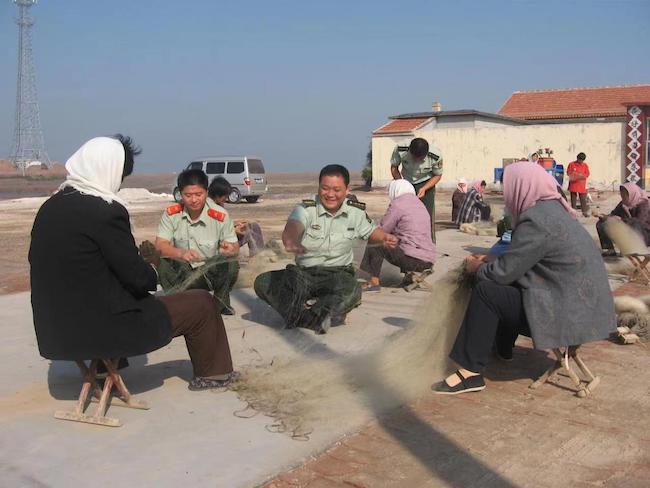 宋萬民幫助漁民修補漁網。 濱州市公安局海岸警察支隊岔尖派出所供圖