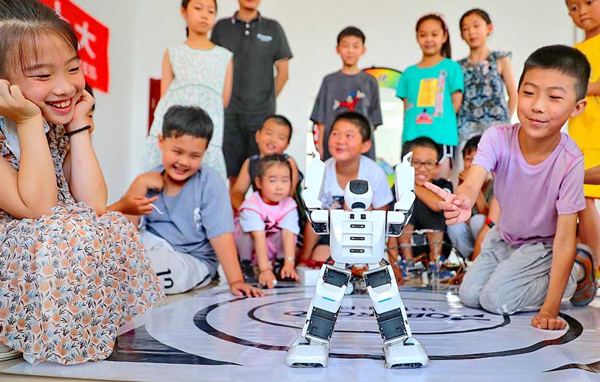 2022年7月19日，河北省秦皇島市海港區(qū)白塔嶺街道秦皇半島第二社區(qū)內(nèi)，小朋友正在觀看“機(jī)器人跳舞”。 曹建雄攝