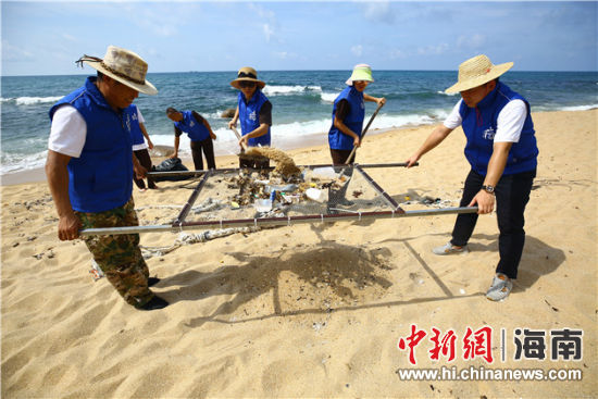 環(huán)保志愿者用篩網(wǎng)“淘”出海灘上的垃圾。