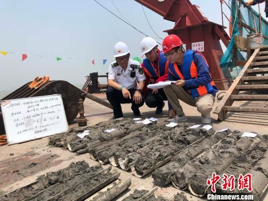 圖為勘察設計人員與海事局工作人員查看巖芯情況。　魏震 攝