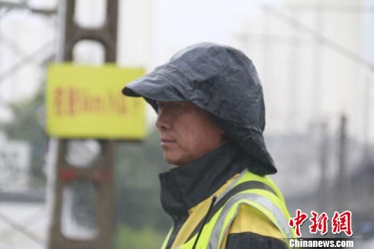蘭州西工務(wù)段蘭州線(xiàn)路車(chē)間防護(hù)員雨中巡查。　王光輝 攝